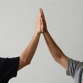 Two people doing a high-five, palms meeting with all fingers
