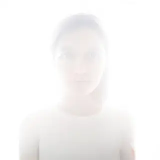 A high-key portrait of a person against a bright white backg