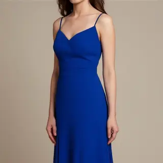 A woman wearing a royal blue evening dress against a neutral