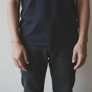 A person standing with both hands visible at their sides, fi