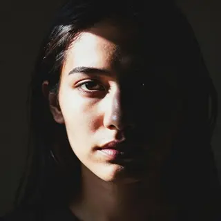 A portrait with dramatic split lighting — half the face brig