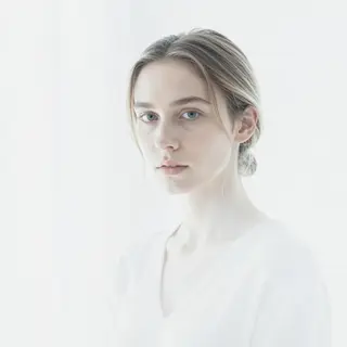 A high-key portrait of a person against a bright white backg
