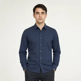 A man standing straight facing the camera, hands in pockets,