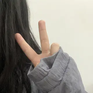 A person making a peace sign with their right hand, clearly 