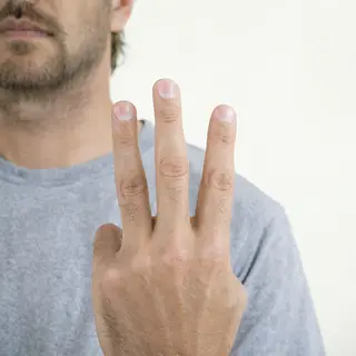 A person counting to three on their fingers, with index, mid