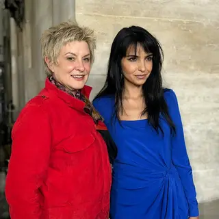 Two women standing side by side: one with short blonde hair 