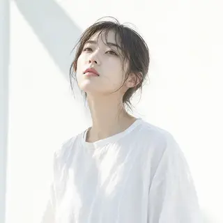 A high-key portrait of a person against a bright white backg