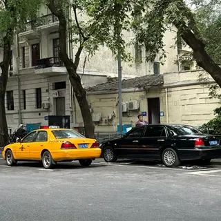 A yellow taxi and a black limousine parked next to each othe