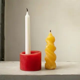A tall thin white candle, a short fat red candle, and a medi