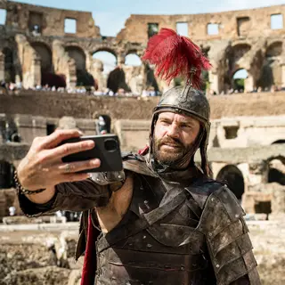 A Roman gladiator taking a selfie with a smartphone in the C