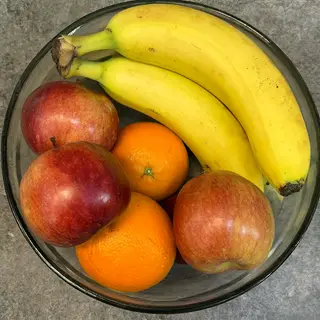 A fruit bowl containing exactly 3 bananas, 4 oranges, and 2 