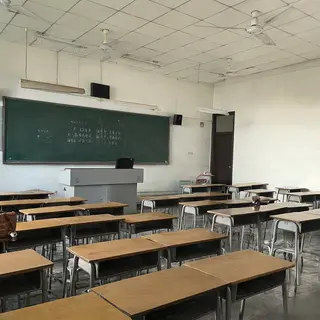 A classroom with desks and a chalkboard but no students