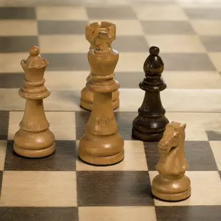 Five chess pieces on a board: a king in the center, a queen 