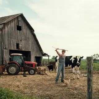 A farm scene with a barn, tractor, farmer, cow, chicken, and
