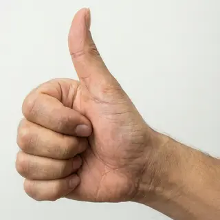 A hand giving a thumbs-up with four fingers curled and thumb