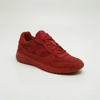 A single red sneaker on a clean white background with soft s