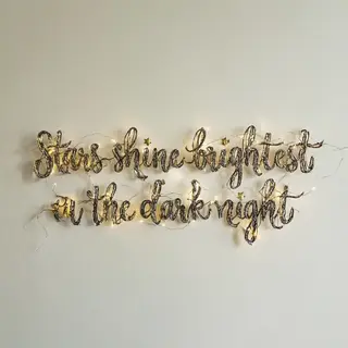 'Stars shine brightest in the dark night' displayed on a cle