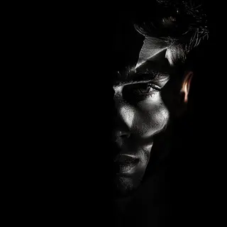 A portrait with dramatic split lighting — half the face brig