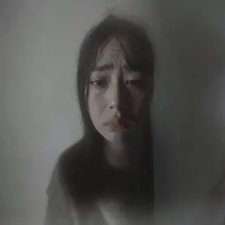 A face showing quiet melancholy — downcast eyes, slightly dr