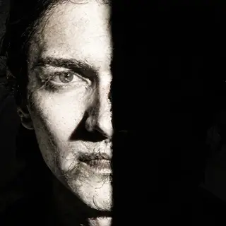 A portrait with dramatic split lighting — half the face brig