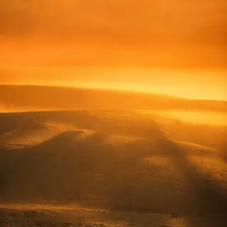 A landscape photograph bathed in golden hour light — long wa