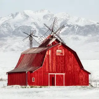 A landscape with a red barn in the foreground at large scale