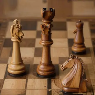 Five chess pieces on a board: a king in the center, a queen 