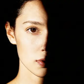 A portrait with dramatic split lighting — half the face brig