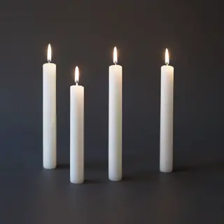 Exactly 4 white candles standing on a dark surface