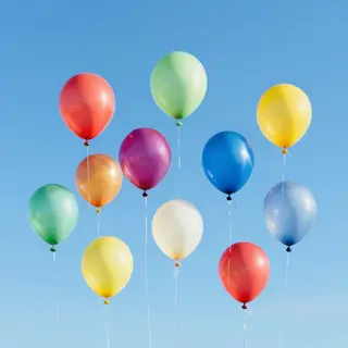 Exactly 11 colorful balloons floating against a clear blue s