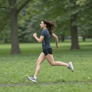 A woman mid-stride running through a park, hair and clothes 