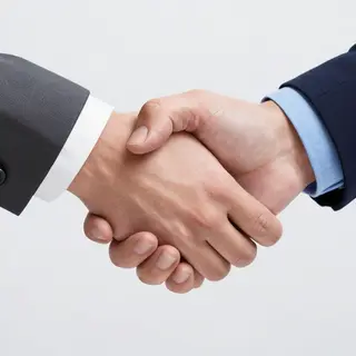 Two people shaking hands in a professional setting, all fing