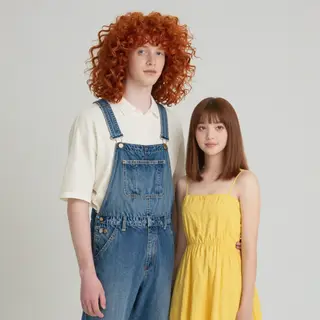 Two friends posing: one tall with curly red hair in denim ov