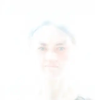 A high-key portrait of a person against a bright white backg