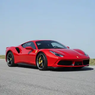 A bright red sports car parked on a gray asphalt road — the 