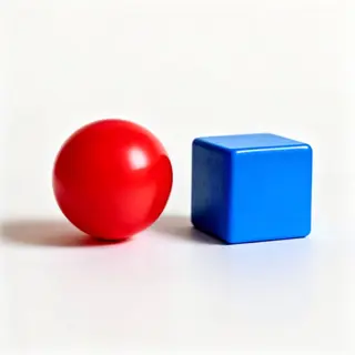 A red ball and a blue cube sitting side by side on a white s