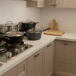 A kitchen with pots, pans, a stove, and a cutting board but 