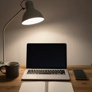A desk scene: laptop in the center, coffee mug to the left, 