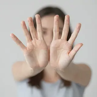 A woman holding her hands out in front of her palms-up, all 