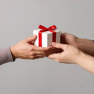One person handing a small gift box to another person, both 