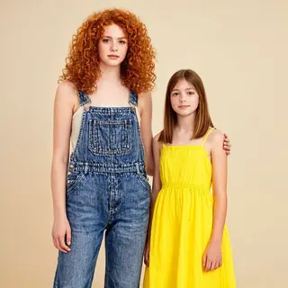 Two friends posing: one tall with curly red hair in denim ov