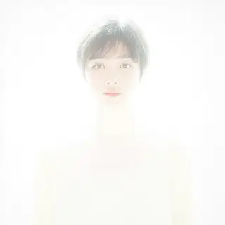 A high-key portrait of a person against a bright white backg