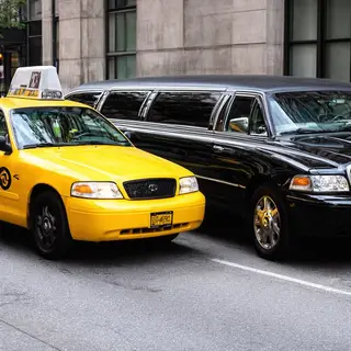 A yellow taxi and a black limousine parked next to each othe