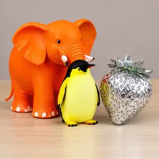 An orange elephant, a yellow penguin, and a silver strawberr