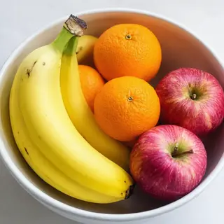 A fruit bowl containing exactly 3 bananas, 4 oranges, and 2 