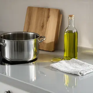 A kitchen counter with a stainless steel pot, a wooden cutti