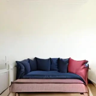 A minimalist room with walls in #F5E6CC (warm cream), a sofa