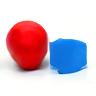 A red ball and a blue cube sitting side by side on a white s
