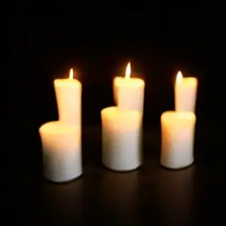 Exactly 4 white candles standing on a dark surface