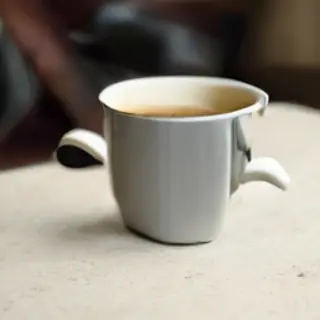 A coffee mug next to an open book on a desk
